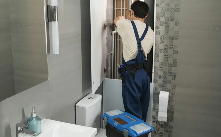 Gasfíter revisando las cañerías de un baño