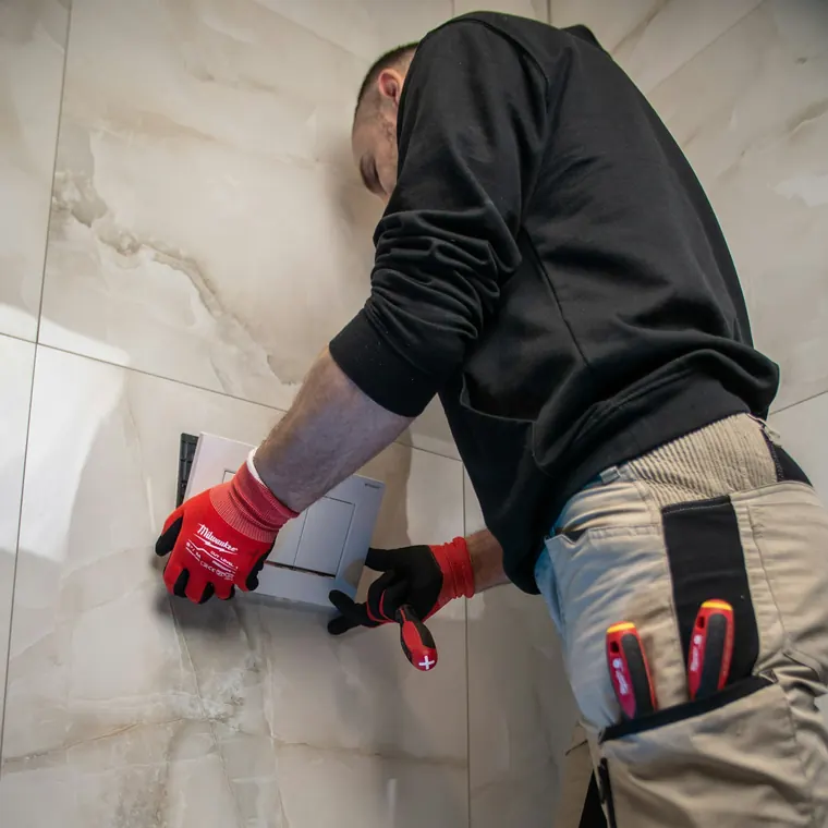 Técnico revisando un muro de baño en busca de una fuga de agua