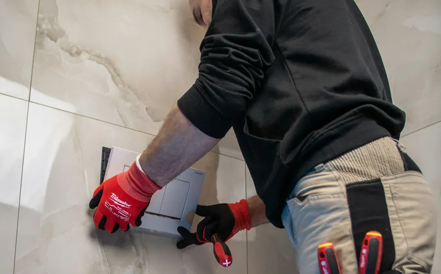 Técnico revisando un muro de baño en busca de una fuga de agua